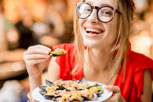 Woman eating mussels at the food market