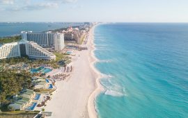 Tourists dip their toes in water as top Mexican beach getaway reopens